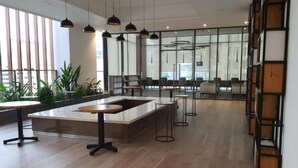 A modern interior with a central island table, multiple seating areas, and pendant lighting. - Capitol Twinpeaks Colombo 2 Sri Lanka Vacation rental - long term (Colombo)