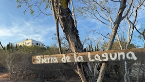 Un cartello di legno con il testo 'Sierra de la Laguna' e un numero di telefono.
