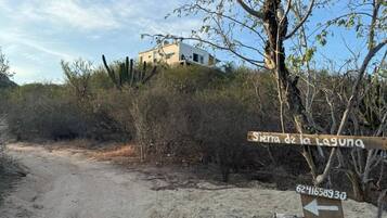 A dirt road leading to a building with a sign indicating 'Sierra de la Laguna'.