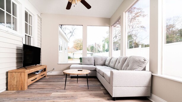 A modern living room with a sectional sofa, a wooden entertainment unit, and a round coffee table. - Hilton`s Luxe Retreat near Ft Benning & Downtown (Columbus)