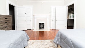 A room with two beds, a fireplace, and a wooden dresser. - Hilton`s Luxe Retreat near Ft Benning & Downtown (Columbus)