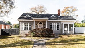 A single-story house with a front porch, a chimney, and a small front yard with a pathway leading to the entrance. - Hilton`s Luxe Retreat near Ft Benning & Downtown (Columbus)