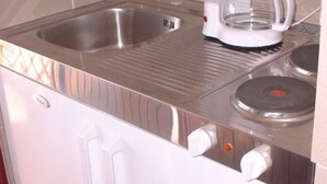 Une cuisine équipée d’un évier en acier inoxydable, d’une machine à café et d’une cuisinière.