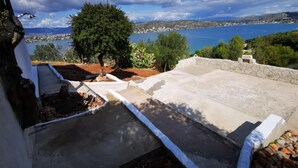 A rooftop terrace with a view of a lake and distant mountains. - House by the sea (Salamina)