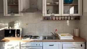A kitchen with white cabinets, a microwave, a stove, a sink, and a dishwasher. - Apartments Jukica - Three Bedroom Apartment With Sea View (Vis)