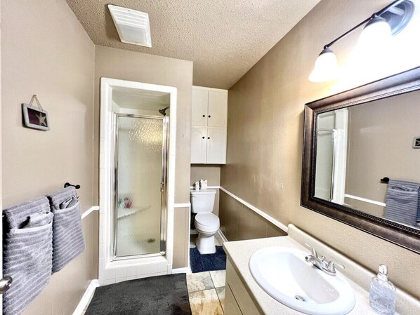Un baño con ducha, inodoro y lavamanos.