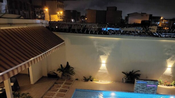 A rooftop pool area with a small covered seating area, surrounded by potted plants and a low wall. - 3-ROOM APARTMENT WITH BALCONY TERRACE GARDEN SWIMMING POOL (Abidjan)