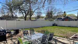 A backyard with a barbecue grill, a table with chairs, and a pool area. - Family and Dog Friendly Modern Traditional Home in Rapid City South Dakota (Rapid City)