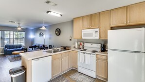 Una cocina moderna con armarios de madera, un refrigerador blanco, un microondas y un lavavajillas.