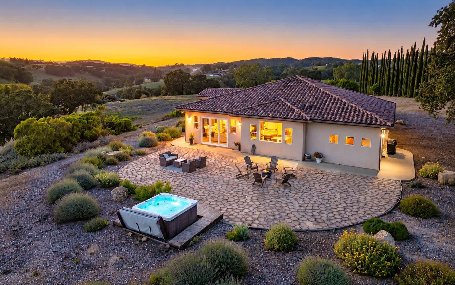 A house with a patio, outdoor seating, and a hot tub.