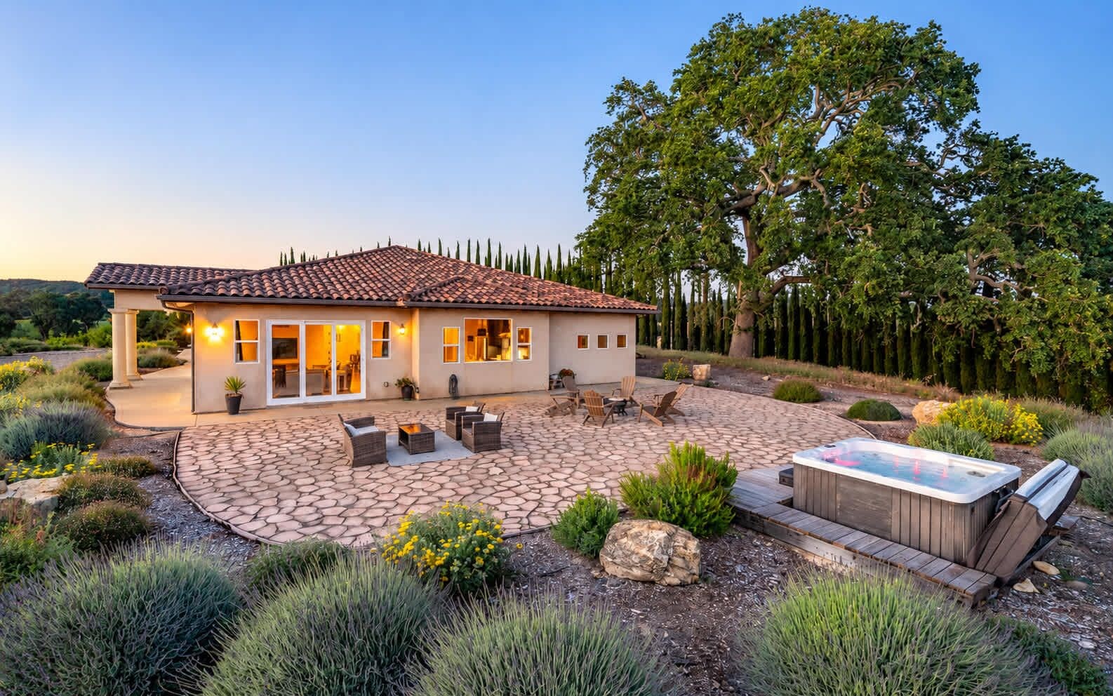 A house with a patio, outdoor seating, and a hot tub.
