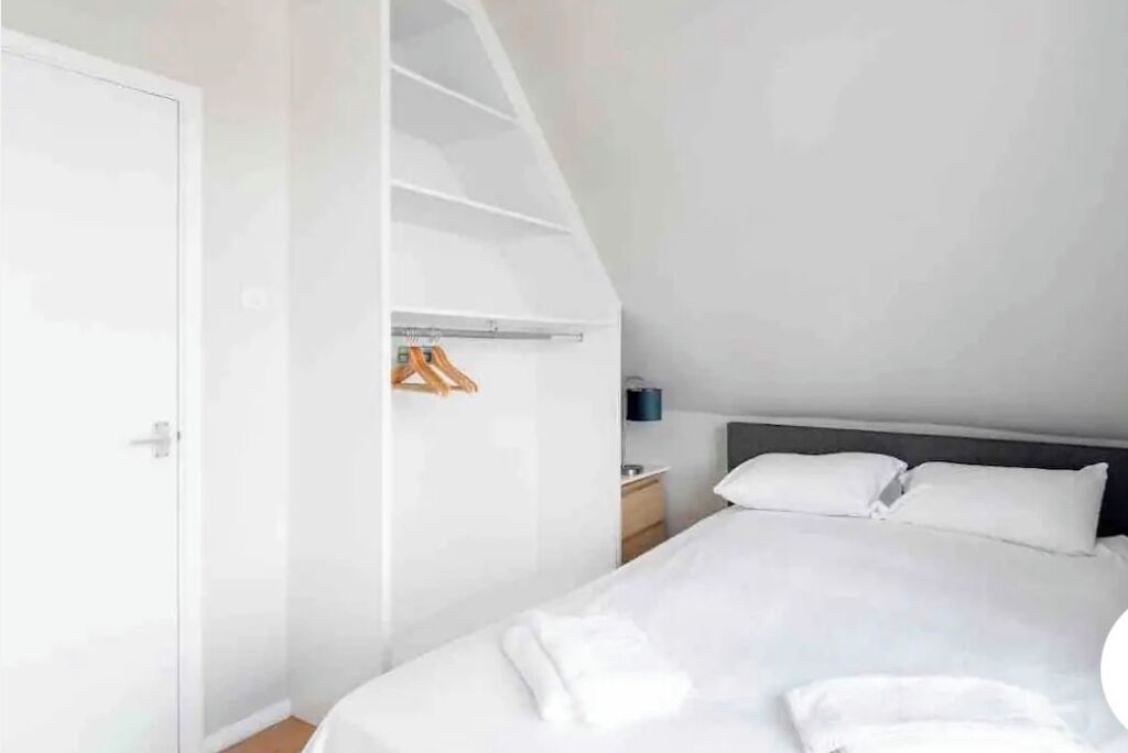 Une chambre à coucher avec un lit, une armoire et une table de chevet.