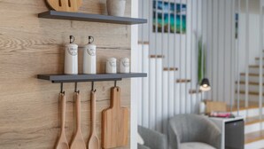 A kitchen with wooden shelves holding kitchen utensils, a plant, and containers labeled with kitchen items. - Apartment BARBARA with private pool (Malinska)