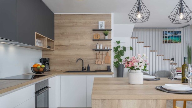 A modern kitchen with wooden accents, a built-in oven, and a dining area with a wooden table and chairs. - Apartment BARBARA with private pool (Malinska)