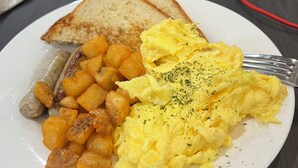 A plate with scrambled eggs, toast, and roasted potatoes.