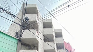 Un hôtel appelé ALWA Suites, doté d’une façade moderne, de grandes fenêtres en verre et d’une entrée bien visible.
