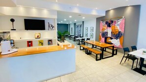 Un restaurant moderne avec un comptoir en bois, plusieurs tables et des chaises.