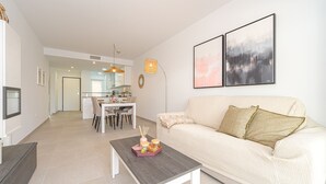 Un salon moderne avec un canapé, une table basse et des œuvres d’art accrochées au mur.