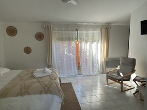 A bedroom with a bed, a chair, a window with curtains, and a view of the outside. - ⭐ STUDIO ESTRELLA – 2 guests – Domaine Astra, Grans (Grans)