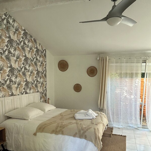 A bedroom with a bed, a ceiling fan, and a view of the outside through a window with curtains. - ⭐ STUDIO ESTRELLA – 2 guests – Domaine Astra, Grans (Grans)