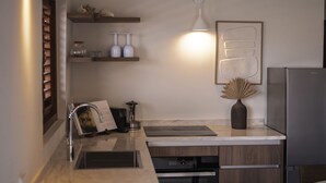 Una cocina moderna con horno empotrado, refrigerador de acero inoxidable y encimera de madera.