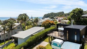 Un quartier résidentiel en bord de mer, avec des maisons modernes, une vue dégagée sur l’océan et une végétation luxuriante.