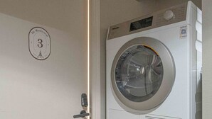 A room with a washing machine and a door with a number plate indicating room 3. - De Montescal - Studio (Paris)