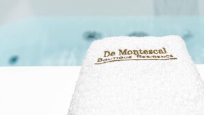 A white towel with "De Montescal Boutique Residence" embroidered on it. - De Montescal - Hot tub & A/C Apartment (Paris)
