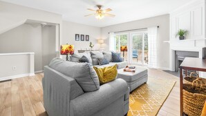 Una sala moderna con un sofá gris, una mesa de centro y una chimenea.