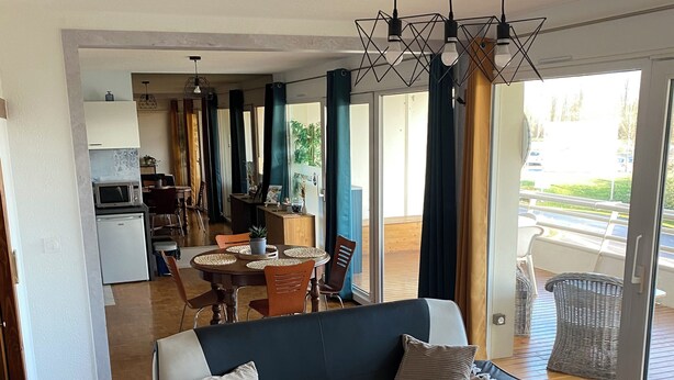 Ein modernes Wohnzimmer mit Sofa, Couchtisch und Essbereich.