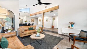 A spacious living area with a leather sofa, a round coffee table, and a ceiling fan. - Gorgeous Papago Retreat w/Pool (Phoenix)
