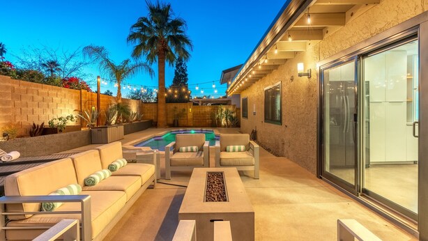 A patio area with a pool, outdoor furniture, and a glass door leading to a room. - Gorgeous Papago Retreat w/Pool (Phoenix)