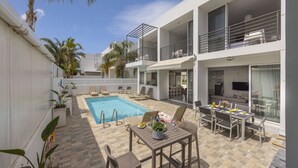 Un hôtel moderne doté d’une piscine, d’un espace extérieur aménagé et de balcons.