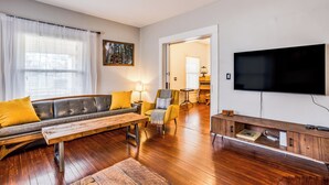 A modern living room with a sofa, coffee table, and TV. - Short Walk to Wesley Hospital | 3 Beds W/ W&D! (Wichita)