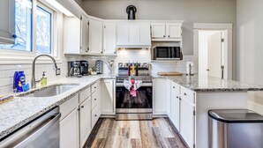 A kitchen with white cabinets, a stainless steel oven, a microwave, and a sink. - Short Walk to Wesley Hospital | 3 Beds W/ W&D! (Wichita)