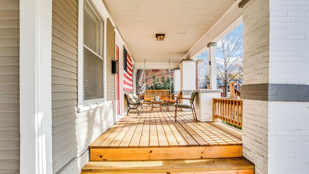 A wooden porch with steps leading to a seating area with chairs and a table. - Short Walk to Wesley Hospital | 3 Beds W/ W&D! (Wichita)