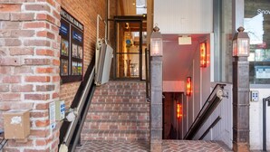 A brick staircase leading to a door with a glass panel, a sign above the door, and a lantern on the right. - 2-Bedroom Top Floor View Condo in Downtown Aspen (Aspen)