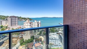 A high-rise building with a view of a coastal cityscape, including a body of water and distant hills. - MHF III Apts Variados a 280m da Praia em Itapema (Itapema)