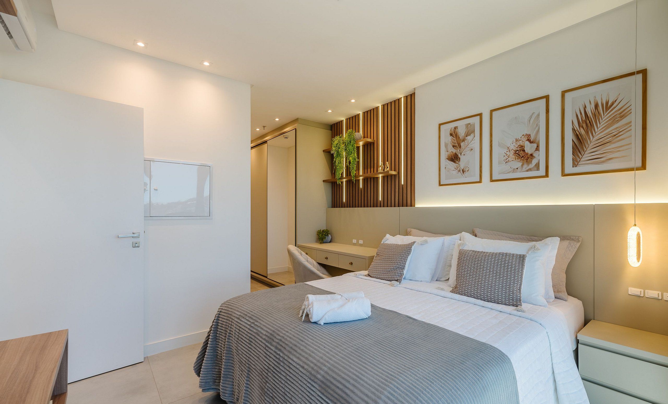 Un dormitorio moderno con cama, mesitas de noche, un espejo y una obra de arte en la pared.