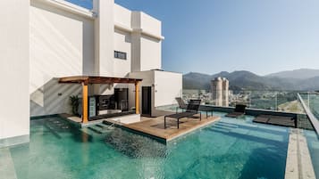 Una piscina al aire libre, sillones reclinables de piscina