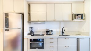 Une cuisine moderne équipée d’appareils électroménagers en acier inoxydable, d’un four à micro-ondes et d’une machine à café.