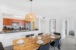 A modern kitchen with wooden cabinets, a stainless steel refrigerator, and a built-in oven. - 1200 Brickell - Miami stay - We Host (Miami)