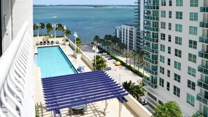Un hotel moderno con piscina, palmeras y vista al océano.
