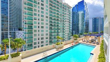A hotel pool area with a clear view of high-rise buildings in the background.