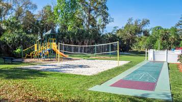 A playground with a slide, climbing structures, and a netted area.