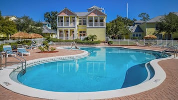 Una piscina al aire libre, sillones reclinables de piscina