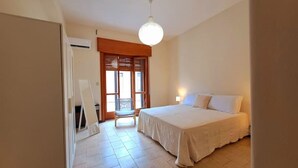 Una camera da letto con un letto, una sedia e una finestra.