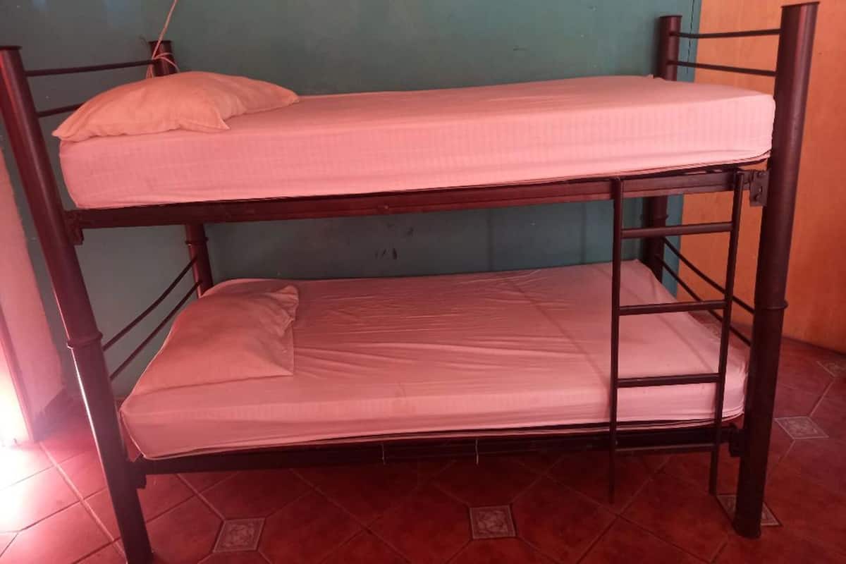 Ein Etagenbett mit zwei Schlafstellen, jeweils mit Kissen und Matratze.