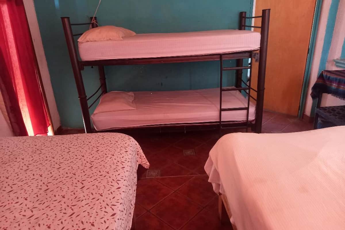 Ein Schlafsaalzimmer mit Etagenbetten und zwei Einzelbetten.