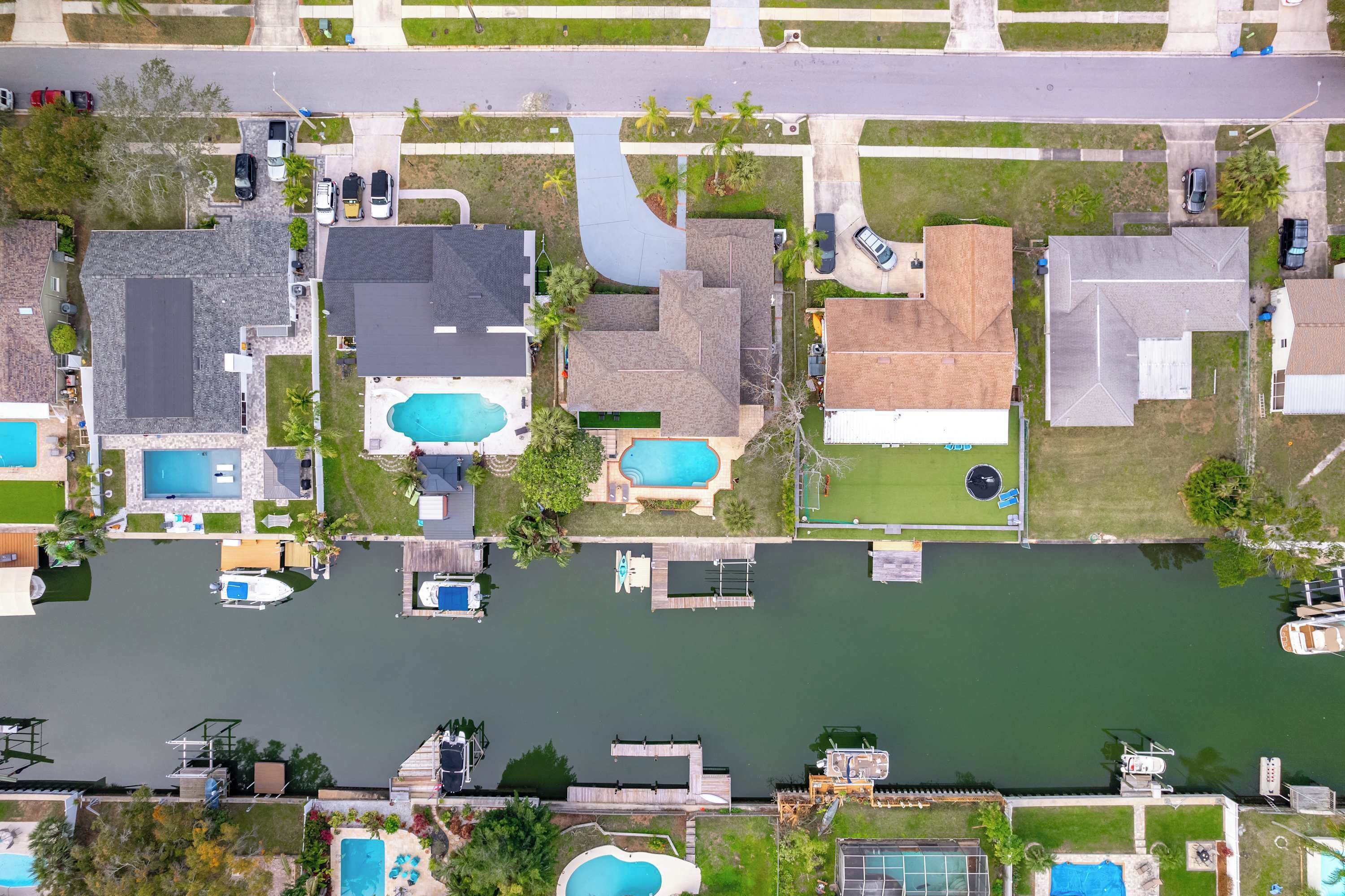 Vista aérea de una zona residencial con casas, piscina y muelle.